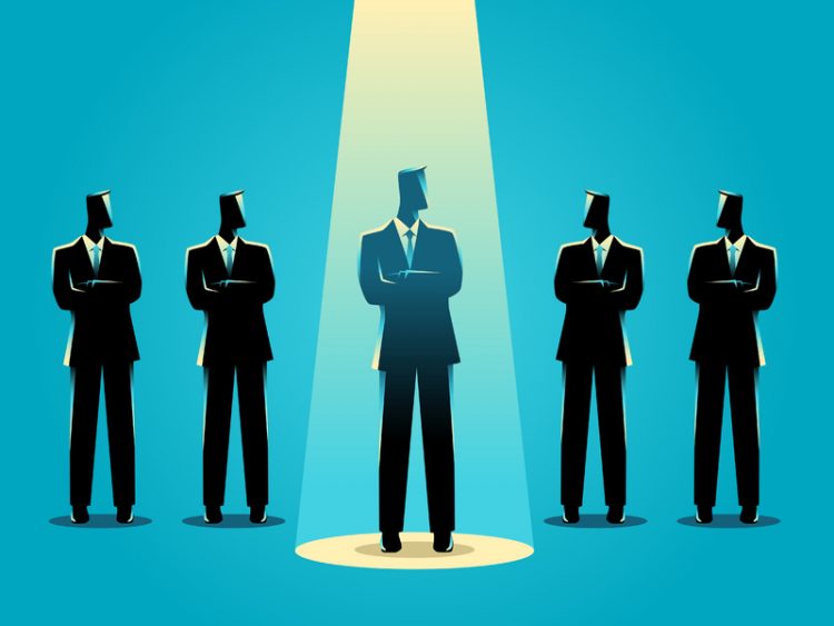 Un dessin de cinq hommes d'affaires les uns à côté des autres. Un est un peu en avant avec une lumière sur lui.