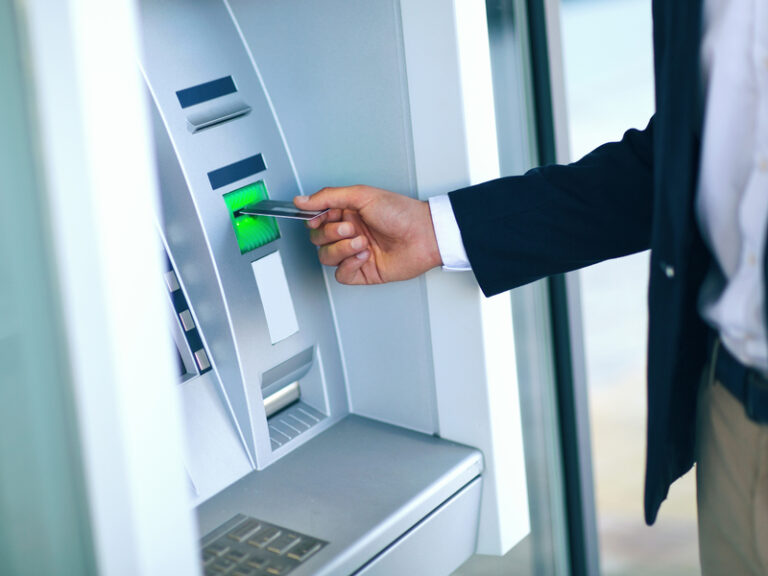 Un homme d'affaires retirant de l'argent à un ATM.