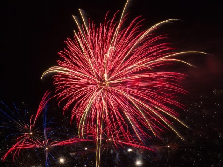 Un feu d'artifice rouge dans un ciel de nuit.