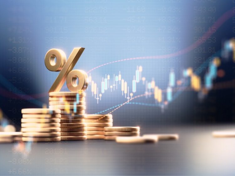 Signe de pourcentage au-dessus des piles de pièces avant le graphique financier bleu.
