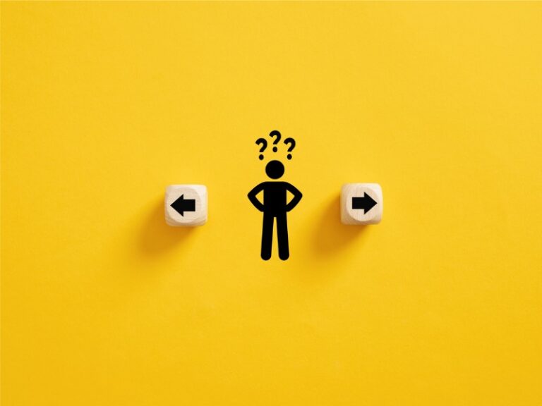 Prise de décision et choix de la bonne voie. Confusion quant au choix de la direction à prendre. Stickman avec des points d’interrogation debout entre les cubes en bois avec des symboles de flèche.