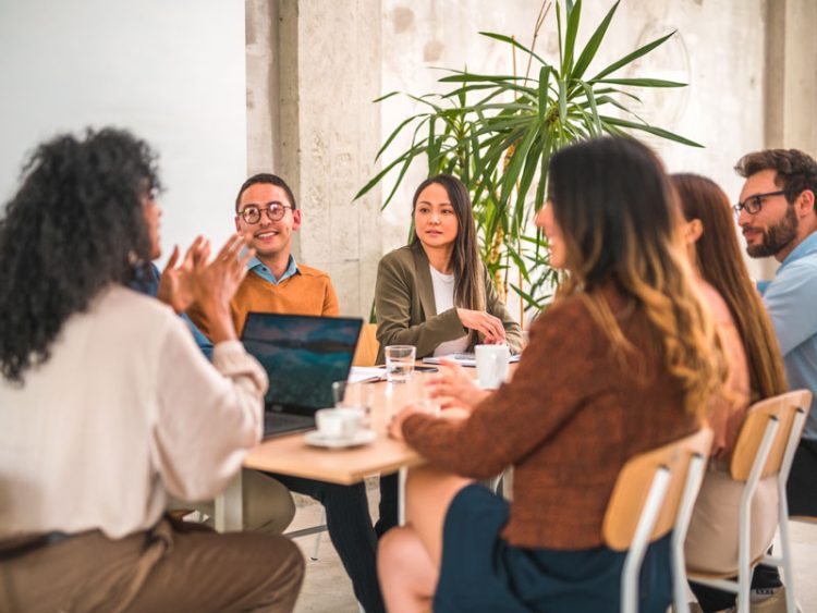 Une réunion d'affaires animée dans un bureau moderne, réunissant des professionnels d'origines et de cultures diverses. Vêtus d'élégantes tenues d'affaires, ils mettent en synergie leur expertise tout en proposant des solutions d'affaires.