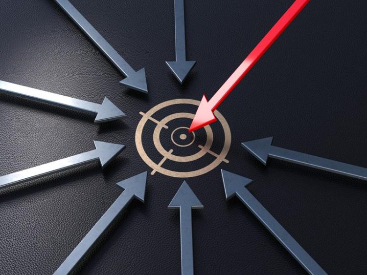 Plusieurs flèches métalliques convergent vers une cible circulaire, symbolisant la concentration et l’atteinte d’objectifs.