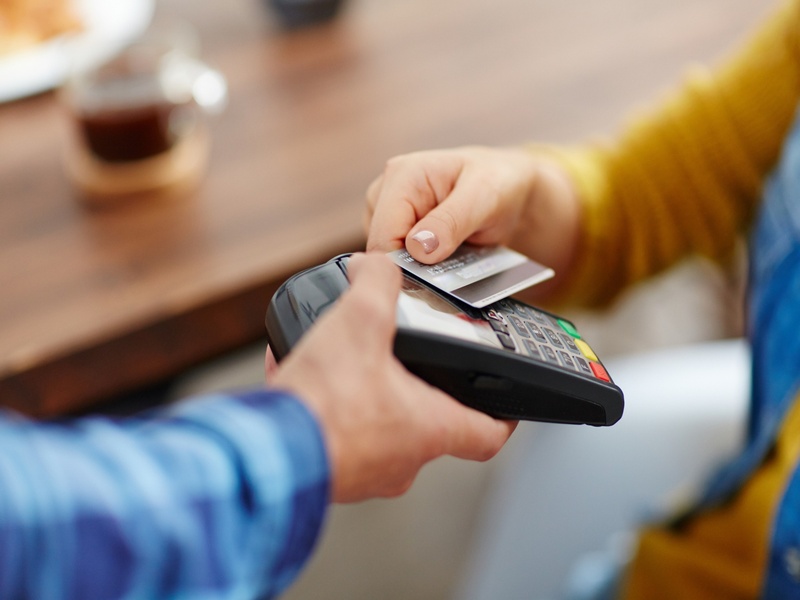 Paiement par carte bancaire sur terminal électronique, représentant les transactions modernes et la consommation.