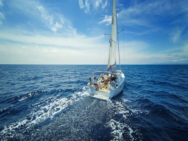 Voilier naviguant en pleine mer sous un ciel dégagé, symbole de liberté et d’évasion.