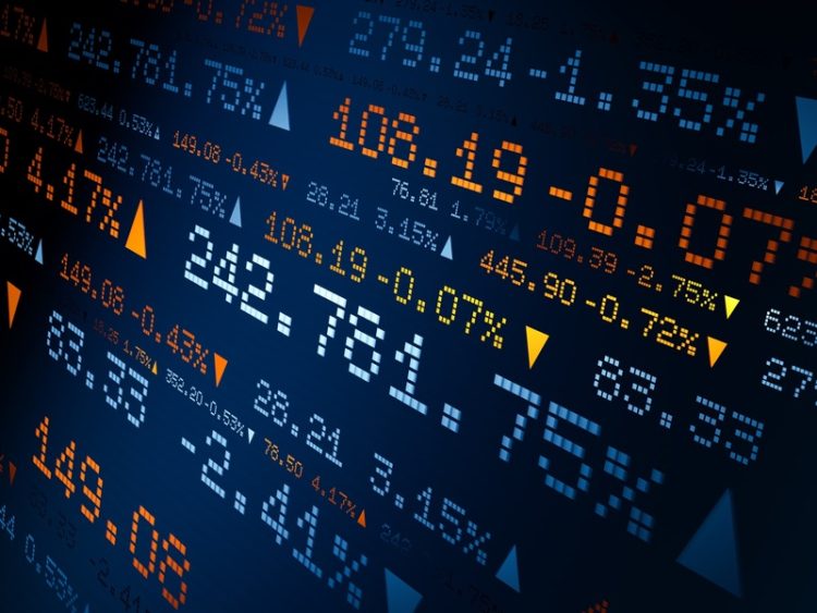 Un écran affiche des cours boursiers, des variations de prix et des indicateurs de marché.