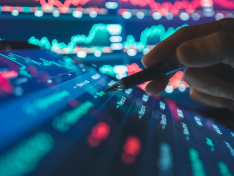 Une personne analyse les mouvements des marchés financiers sur une interface numérique interactive.